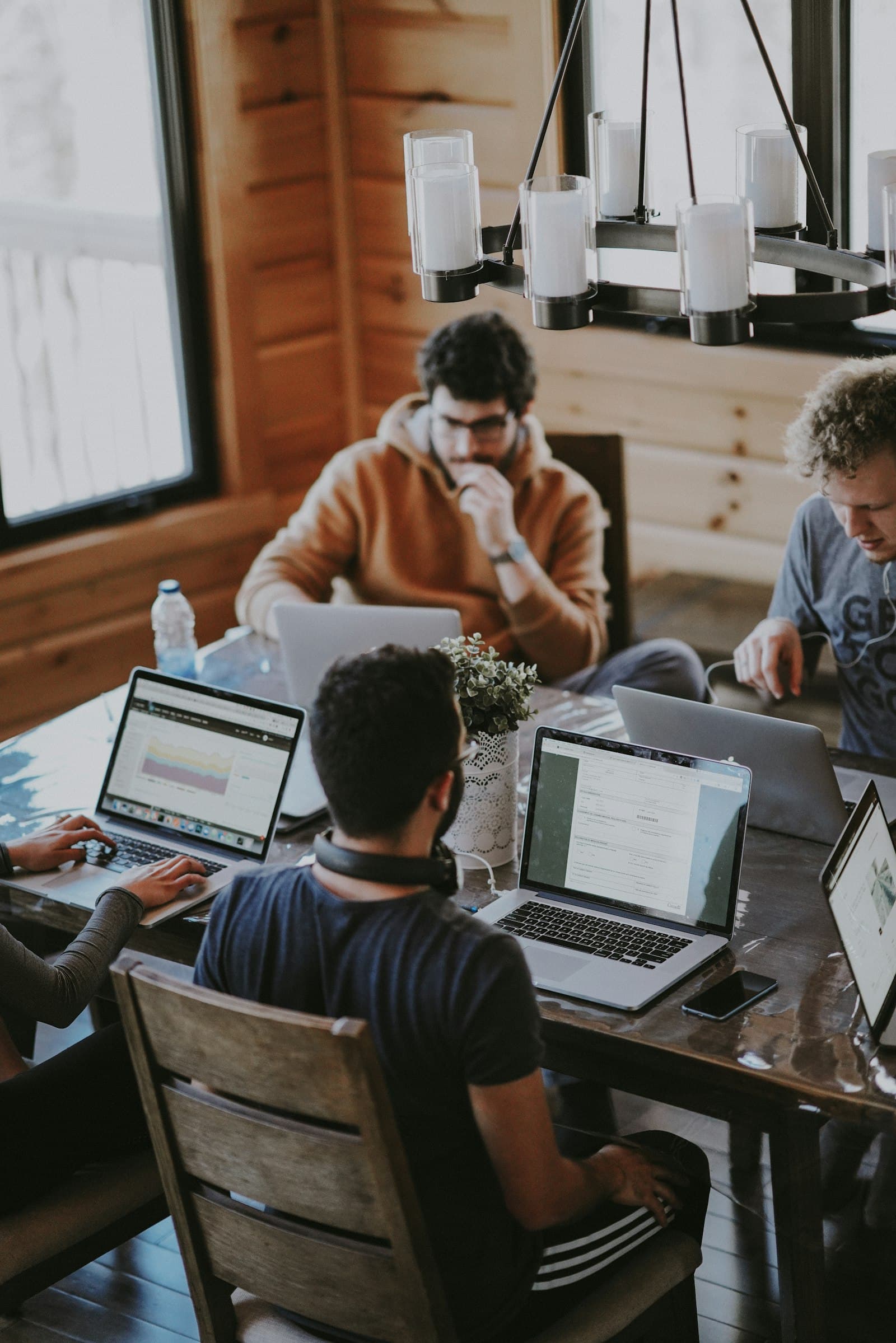 A team of builders heads-down on laptops around a shared table